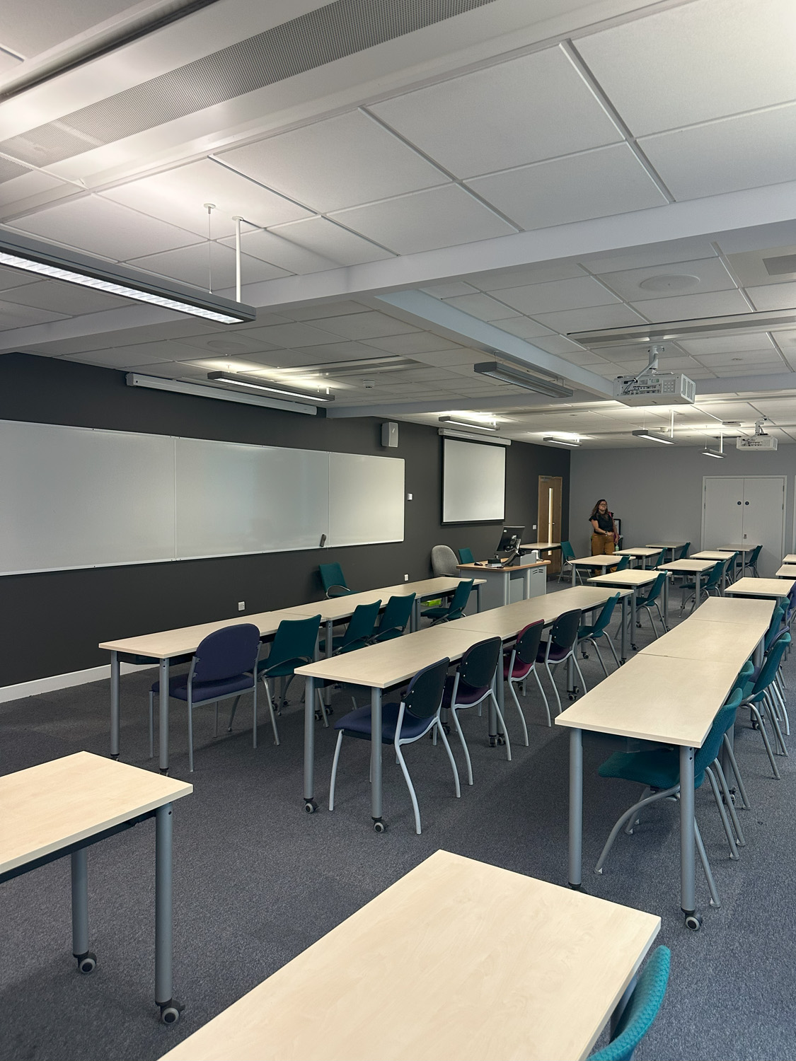 http://university%20lecture%20room.%20Banks%20of%20desks%20all%20at%20one%20level.%20The%20desks%20have%20wheels%20on%20them%20making%20for%20easy%20rearrangement%20of%20the%20room