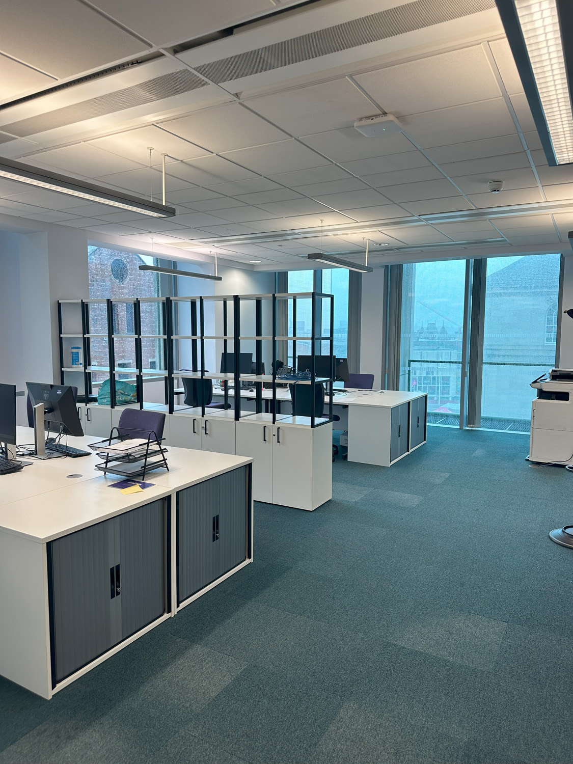 university office space with banks of desks separated by a storage unit